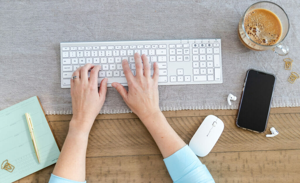photo of hands on the keyboard - presumably deciding on a website platform: Wix vs WordPress